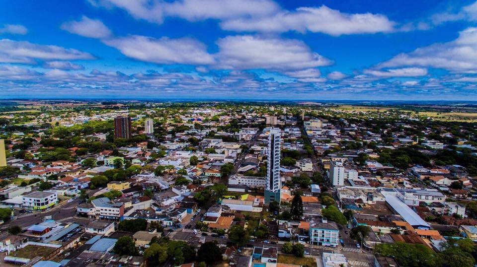 Visão panoramica da cidade com as ruas,casas e o céu azul forte e varias nuvens brancas